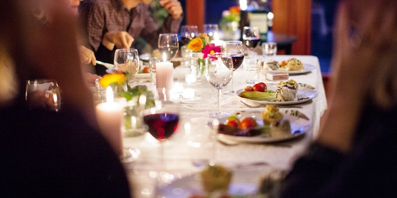 Folk rundt bordet med mat og vin